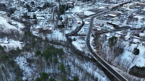 Aerial-tilt-up-reveal-of-snow-covered-ski-town,-Wellsboro-PA