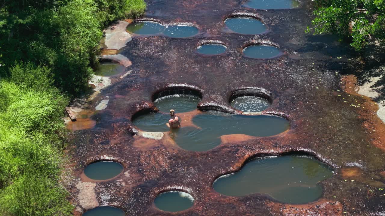 woman enjoying a relaxing bath in the natural pools of Las Gachas River in Colombia