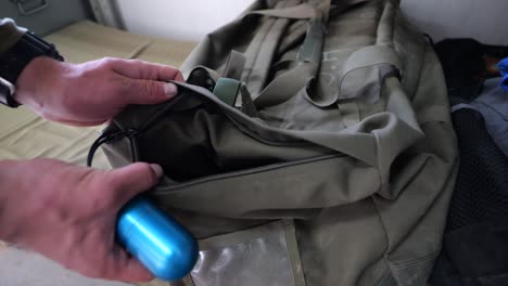 soldier putting practice grenade in and out of duffel bag, close up