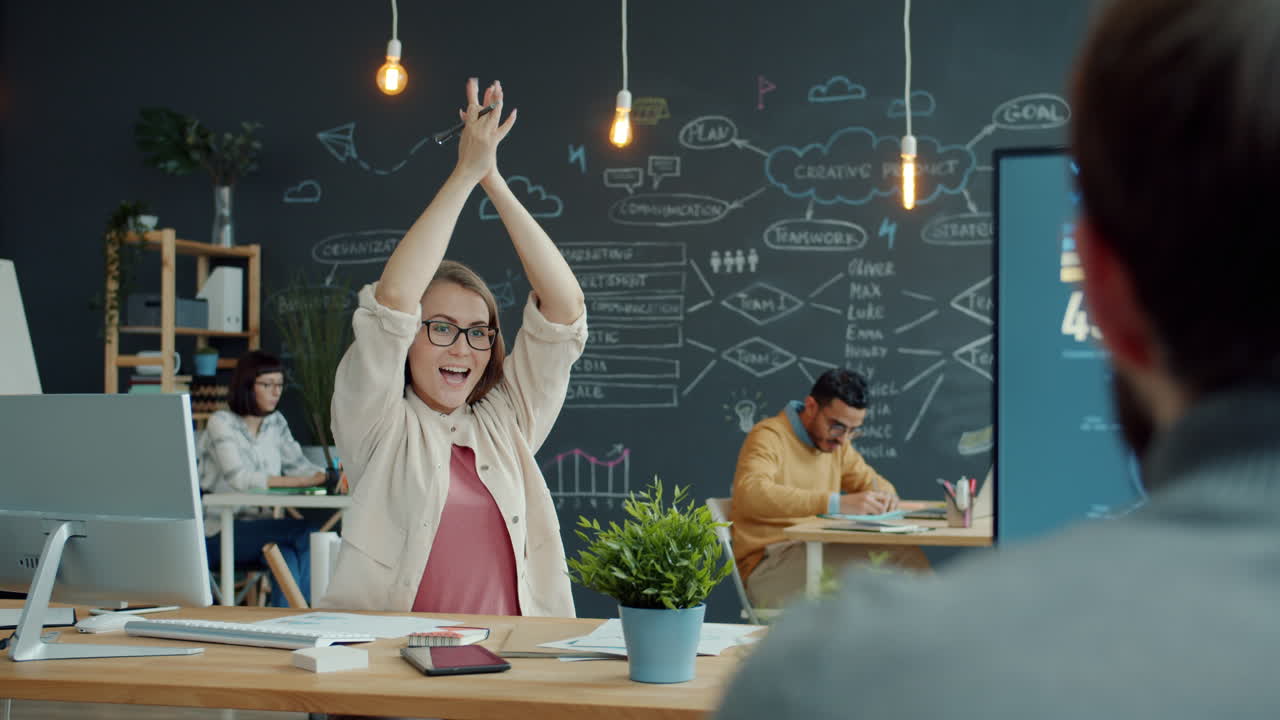 feliz equipo celebrando el éxito en la oficina moderna