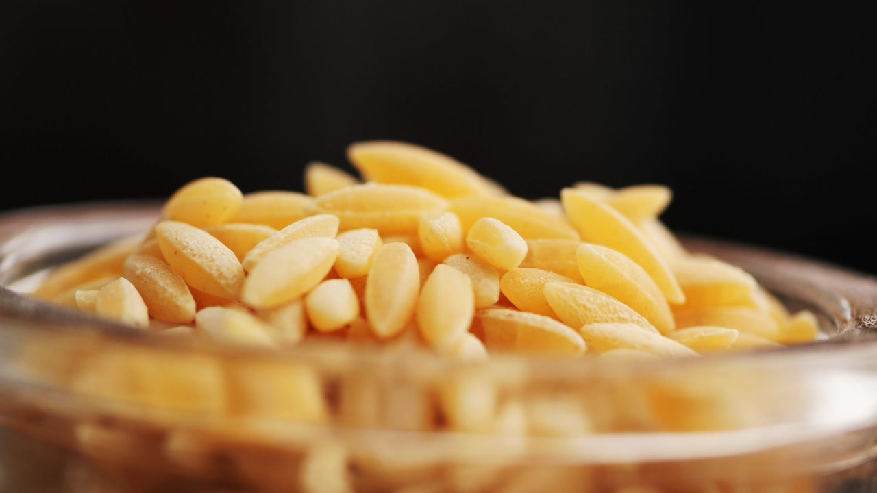 Close-up of Dry Orzo Pasta in a Glass Bowl