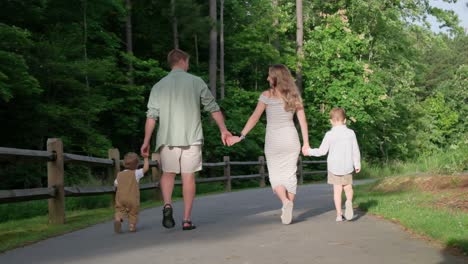 a family strolls a wooded path hand in hand with their dog a family strolls through a serene wooded path joyfully holding hands with their playful dog embodying togetherness in natures idyllic atmosphere