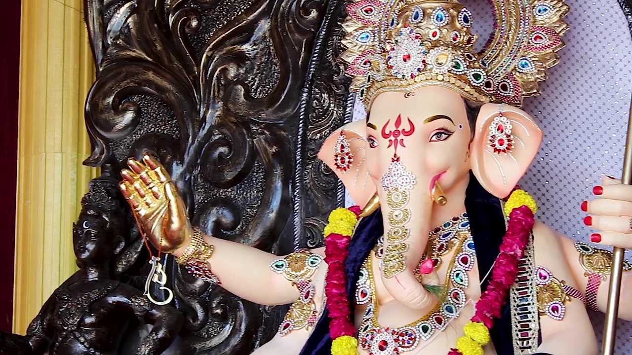 Idolo di Ganesha con corona d'oro, mano benedicente e ghirlanda di calendule durante il festival di Ganesh Chaturthi in India