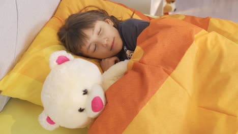 sleepy little cute girl is sleeping in her bed.