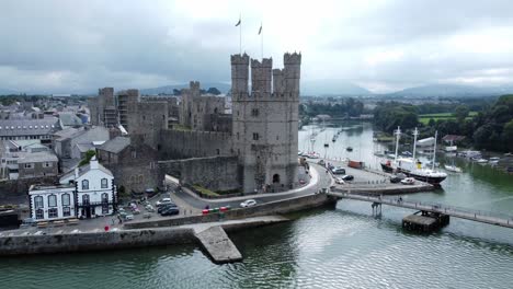 ancient caernarfon castle welsh harbour town aerial view medieval waterfront landmark orbit right above river