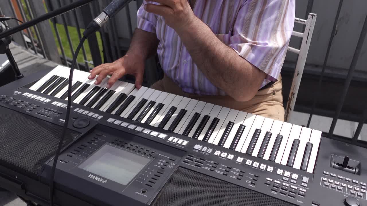 hombre tocando un teclado al aire libre