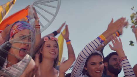 dna structure spinning against group of people clapping together at a concert