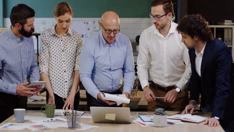 caucasian business team analyzing documents, charts, financial reports and graphics in the office