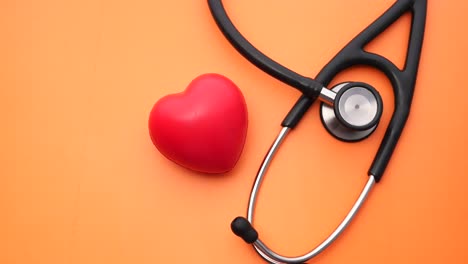 stethoscope and heart on orange background