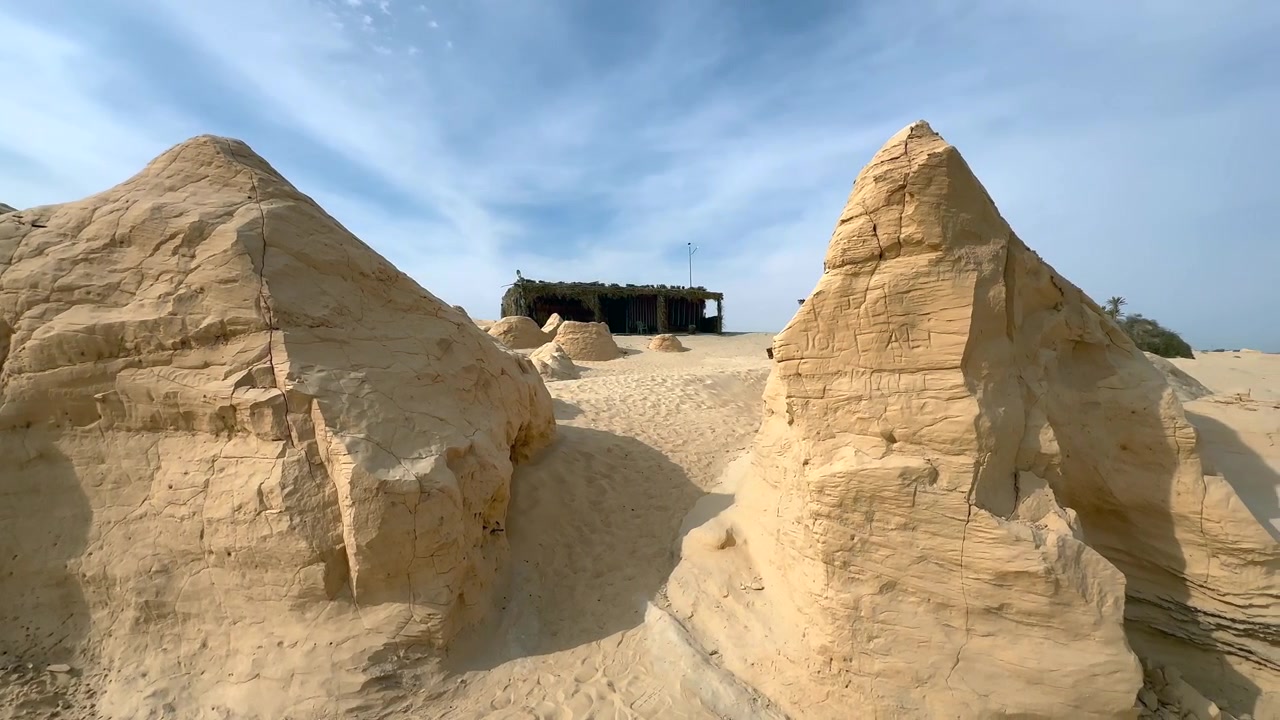Dune di sabbia pietrificate scolpite dal vento (dune pietrificate) sotto un cielo azzurro tenue a Debabcha, Tunisia.