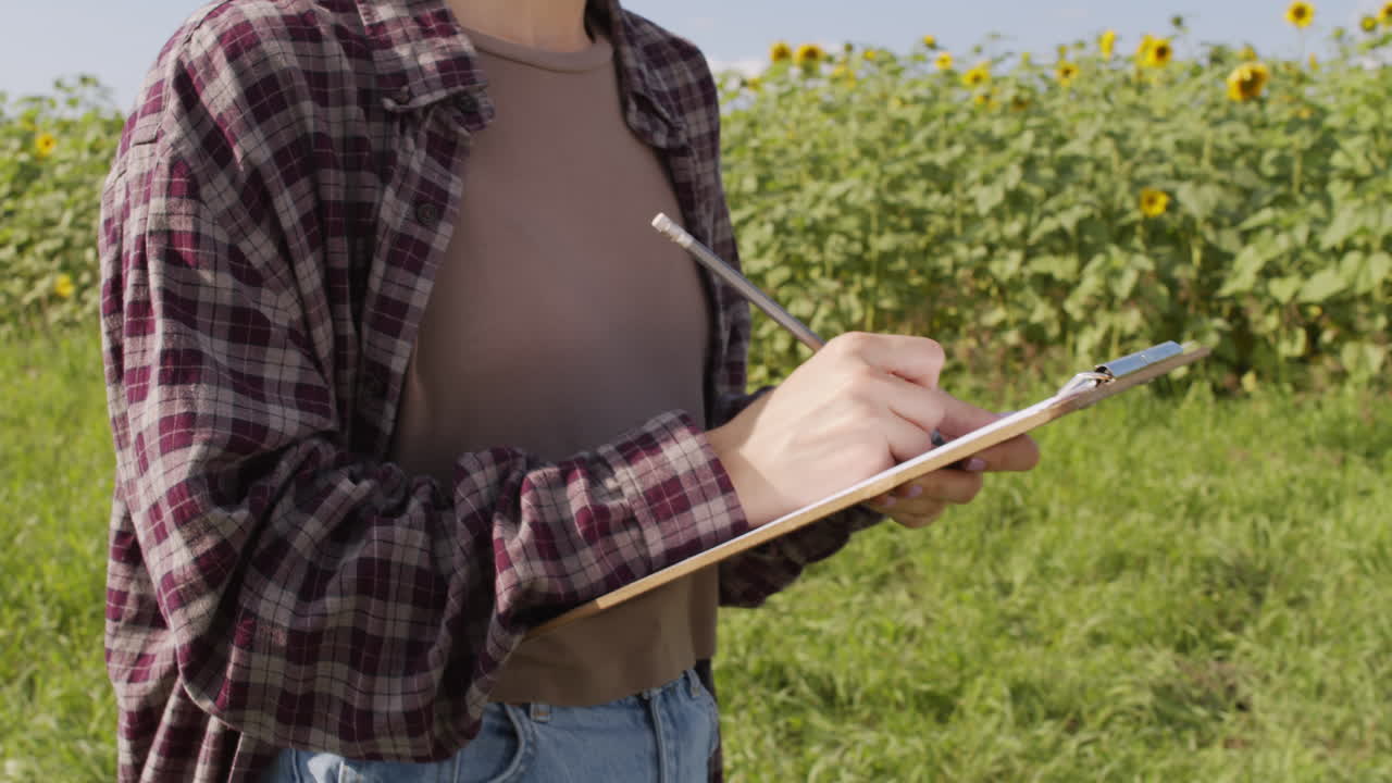 Agronomo irriconoscibile con blocco appunti nel campo