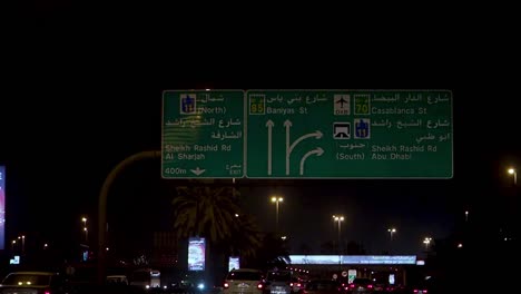 night road signs with arabic and english directions