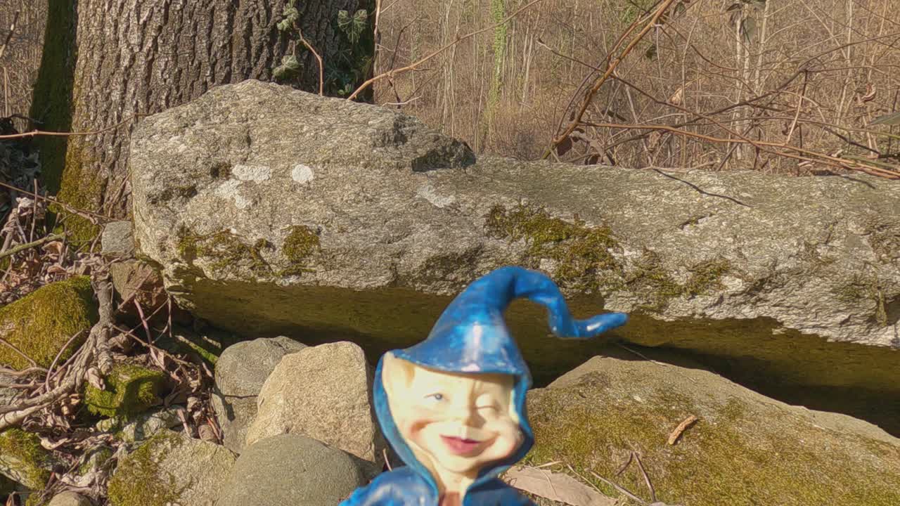 Colorful miniature of elf with blue hat along Invorio trail of elves in Italy