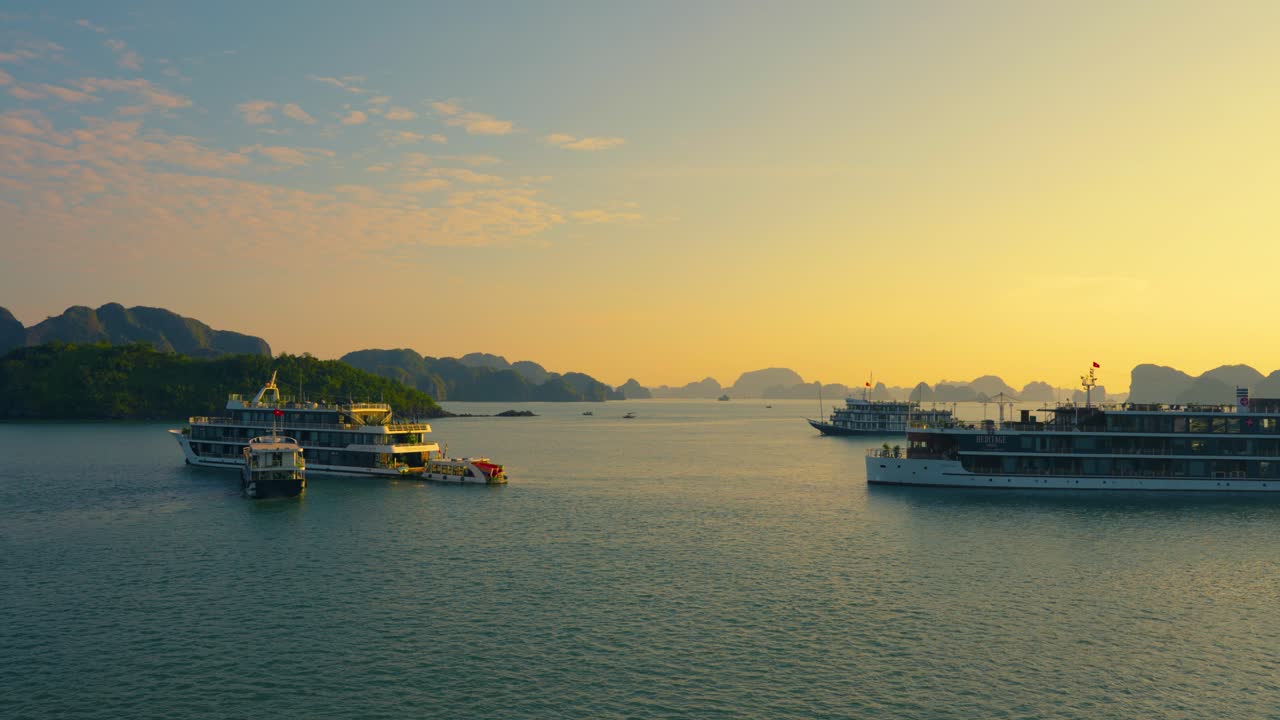 Group of Cruise Ships Anchored at Halong Bay Waters During Spectacular Sunrise Surrounded with Karst Rocky Mountains, Vietnam