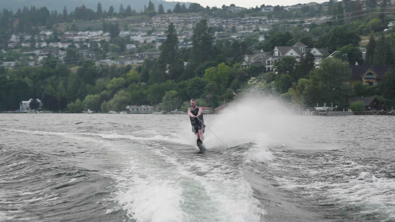 캐나다 오카나간 호수에서 보트를 타고 수상스키를 타는 슬로우 모션 남자