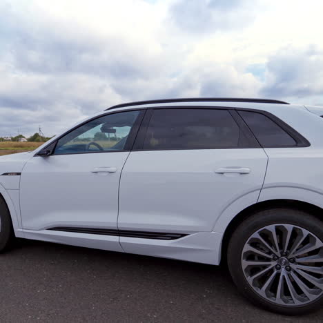 side view on beautiful white audi on the highway. luxury automobile driving on the nature background. slow motion.