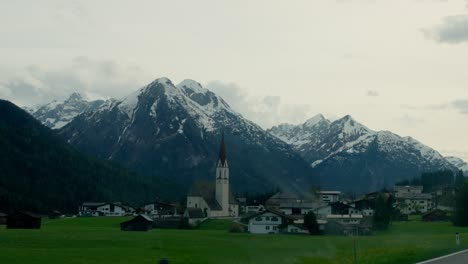 alpine village with church and snow-capped mountains