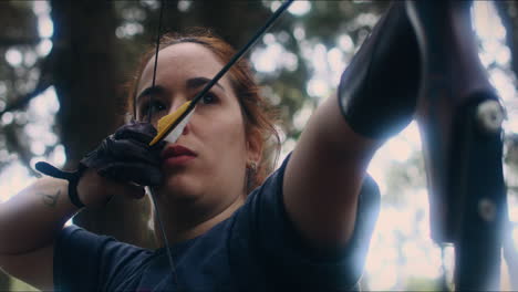 Mujer-De-Tiro-Con-Arco-Tira-Y-Sostiene-Su-Arco-Tiro-Cercano-De-ángulo-Bajo