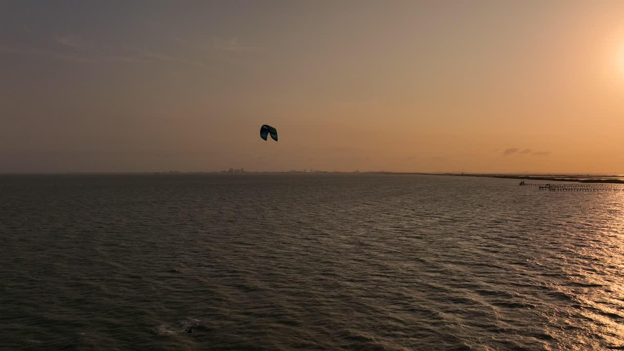 persiguiendo a los kitesurfistas en el golfo de méxico al atardecer