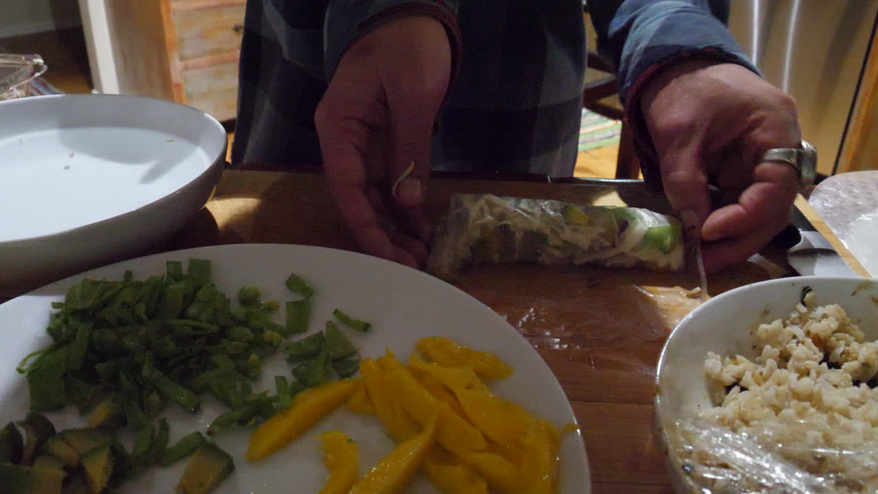 A chef preparing vegan asian spring rolls with vegan ingredients and vegetables in a kitchen