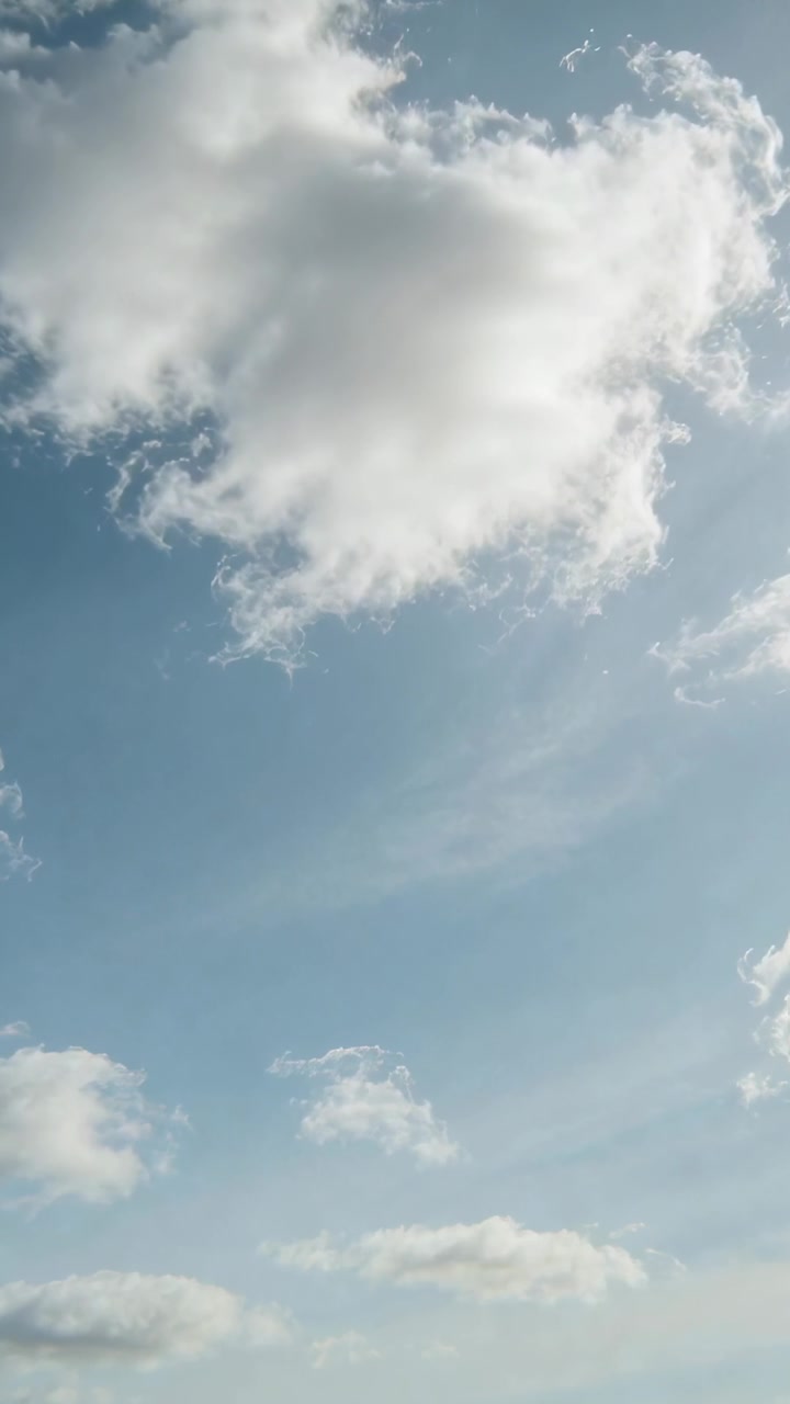 Video verticale: Telecamera inclinata verso l'alto, grande nuvola cumuliforme che si sposta nel cielo blu per un'osservazione costante