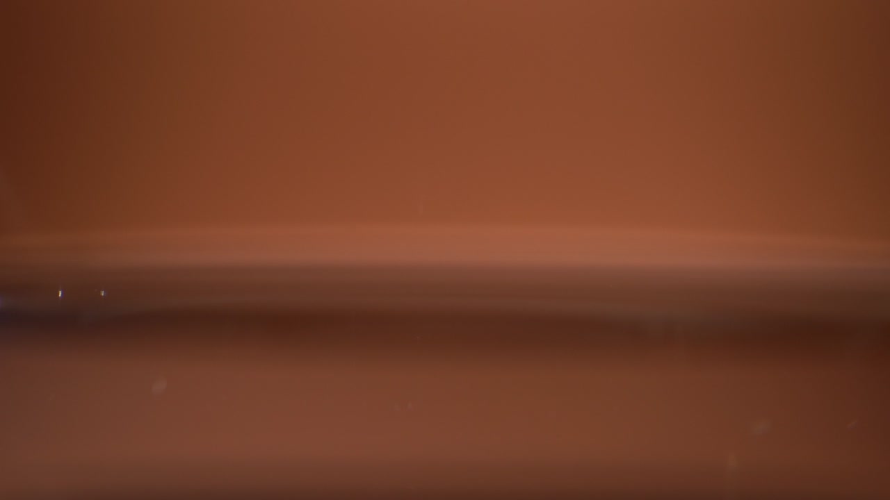 gotas de agua en la superficie del agua sobre fondo naranja de cerca