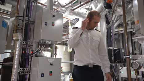 el capitán de los barcos se pone tapones para los oídos mientras trabaja en la sala de máquinas