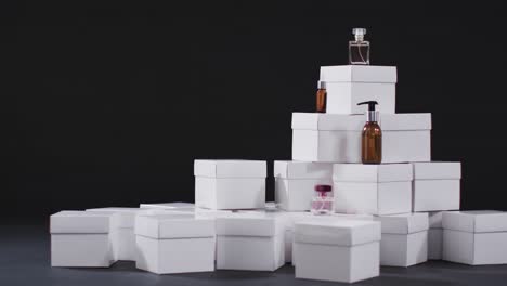 video of beauty products with white cardboard boxes with copy space over black background