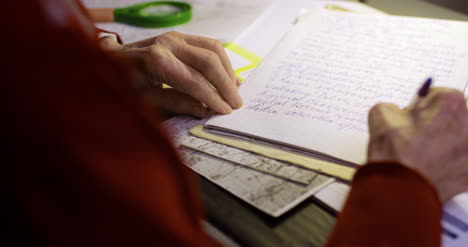 Senior-Businessman-Writing-On-Paper-At-Table-In-Office-3