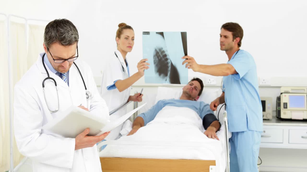 Doctors speaking with sick patient in bed