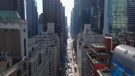 Forwards-fly-above-busy-avenue-between-modern-high-rise-office-downtown-buildings.-Manhattan,-New-York-City,-USA