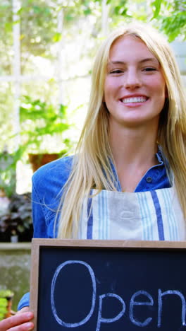 portrait of beautiful woman holding open sign