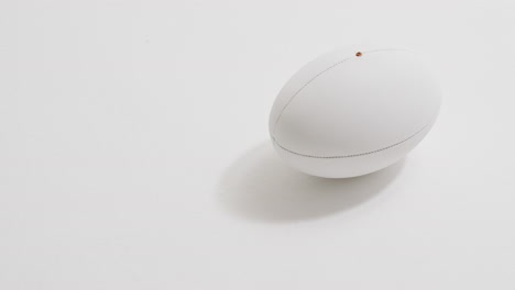 pelota de rugby blanca sobre fondo blanco con espacio de copia, cámara lenta