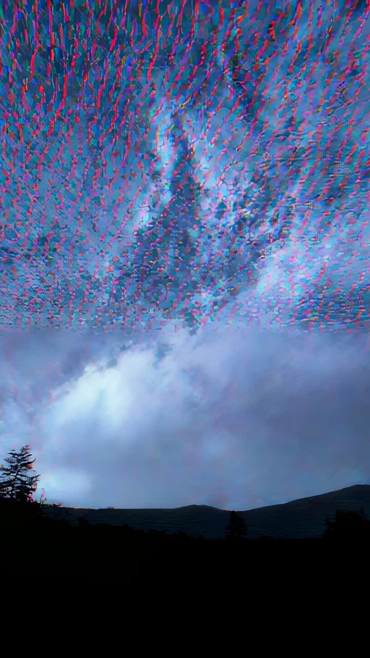 Vertical video: Swirling aurora borealis shifting colors over forest ridge, with silhouetted trees