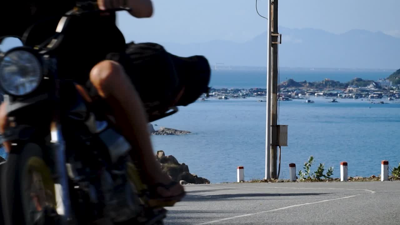 베트남 섬의 아름다운 전망이 있는 도로에서 서핑보드가 부착된 오토바이 타기