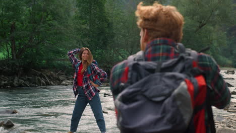 photographer taking photos of girl in mountains. lady making funny poses