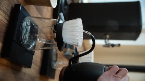 barista making filter coffee by spilling hot water through the filter