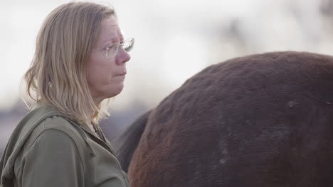 emotional woman slowly nods head as she processes feelings, equine therapy