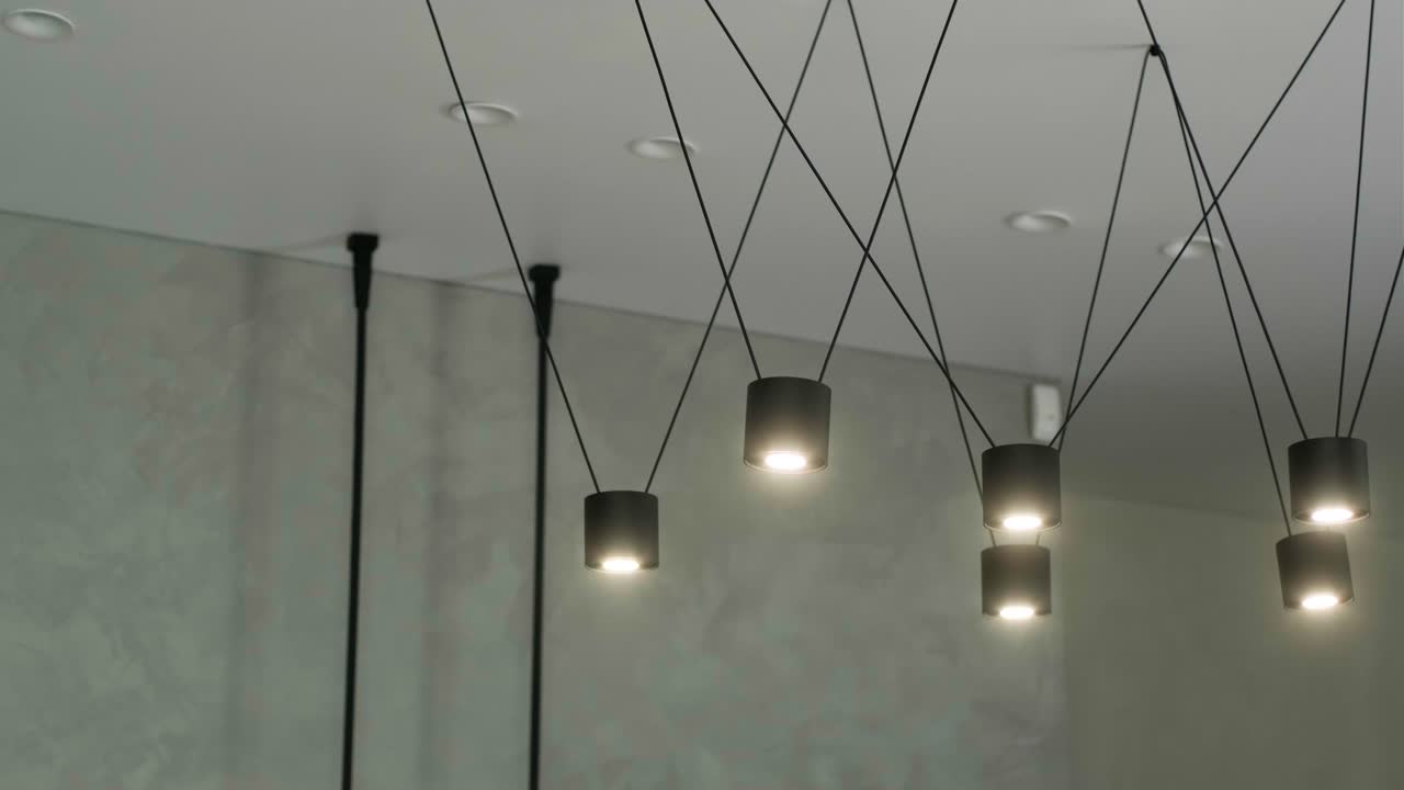 un moderno candelabro de loft hecho de metal negro en un elegante interior blanco. luces de techo de alambre modernas. enfoque selectivo