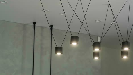 a modern loft chandeliers made of black metal in a stylish white interior. modern wire ceiling lights. selective focus