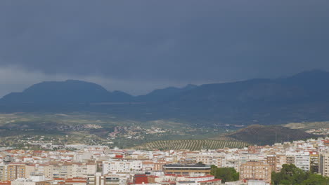 Wolkige-Landschaft-Einer-Andalusischen-Stadt-Mit-Olivenbäumen-Und-Bergen-Im-Hintergrund