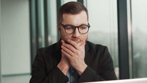 close-up of a man's face with confused emotions from what he saw behind the laptop screen