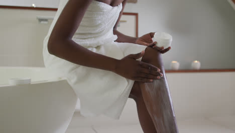 Mujer-Atractiva-Afroamericana-Aplicando-Bálsamo-Corporal-En-El-Baño.