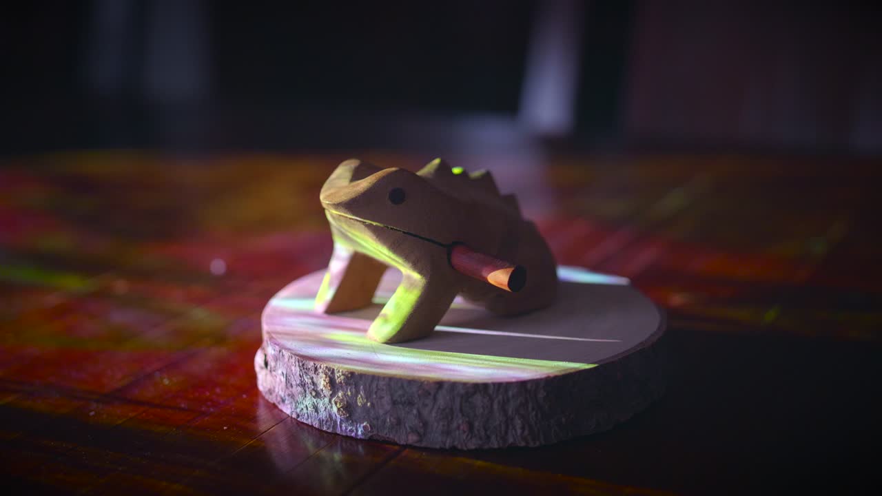 옆구리에 막대기가 있는 나무로 만든 장난감 개구리