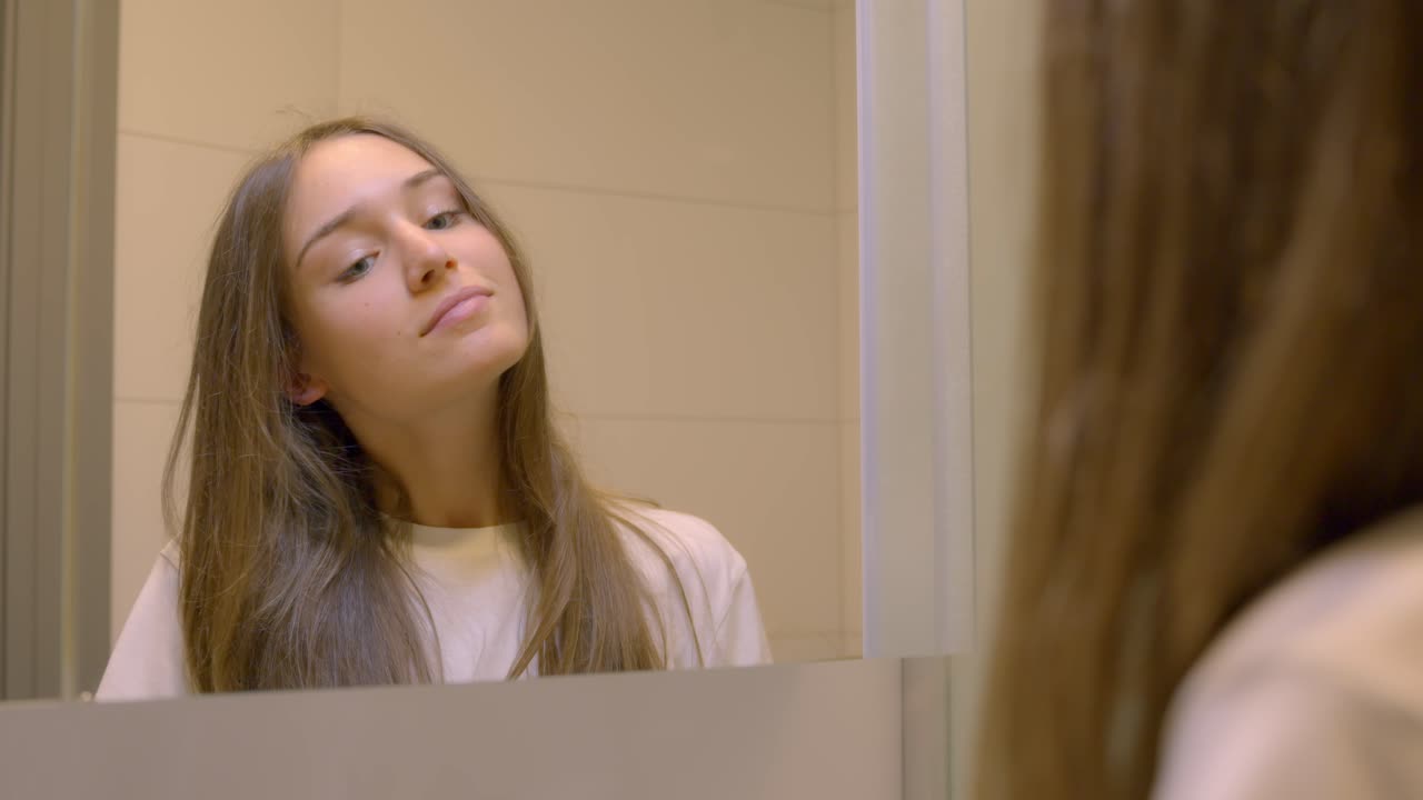 Giovane donna che si sente fiduciosa in una mattina felice, vista allo specchio