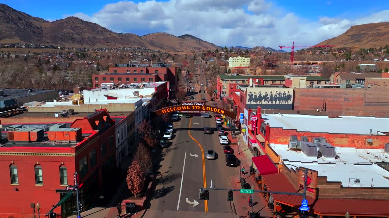 Welcome to historic downtown Golden Colorado aerial drone Coors Beer Factory North Table Mountain Mesa Golden Gate Canyon winter sunny morning afternoon blue sky businesses buildings cars upwards