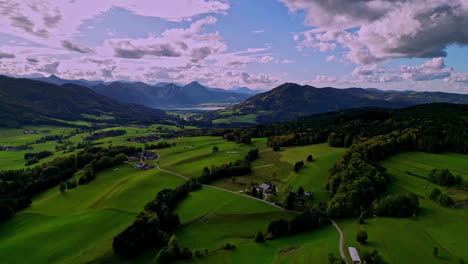 alpine countryside landscape with green fields, clouds and villages