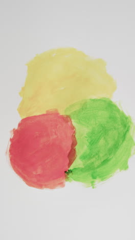 vertical video of red, yellow and green powders with copy space on white background