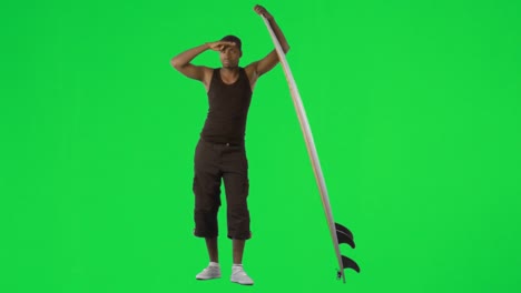 ethnic boy with a surfboard against green screen