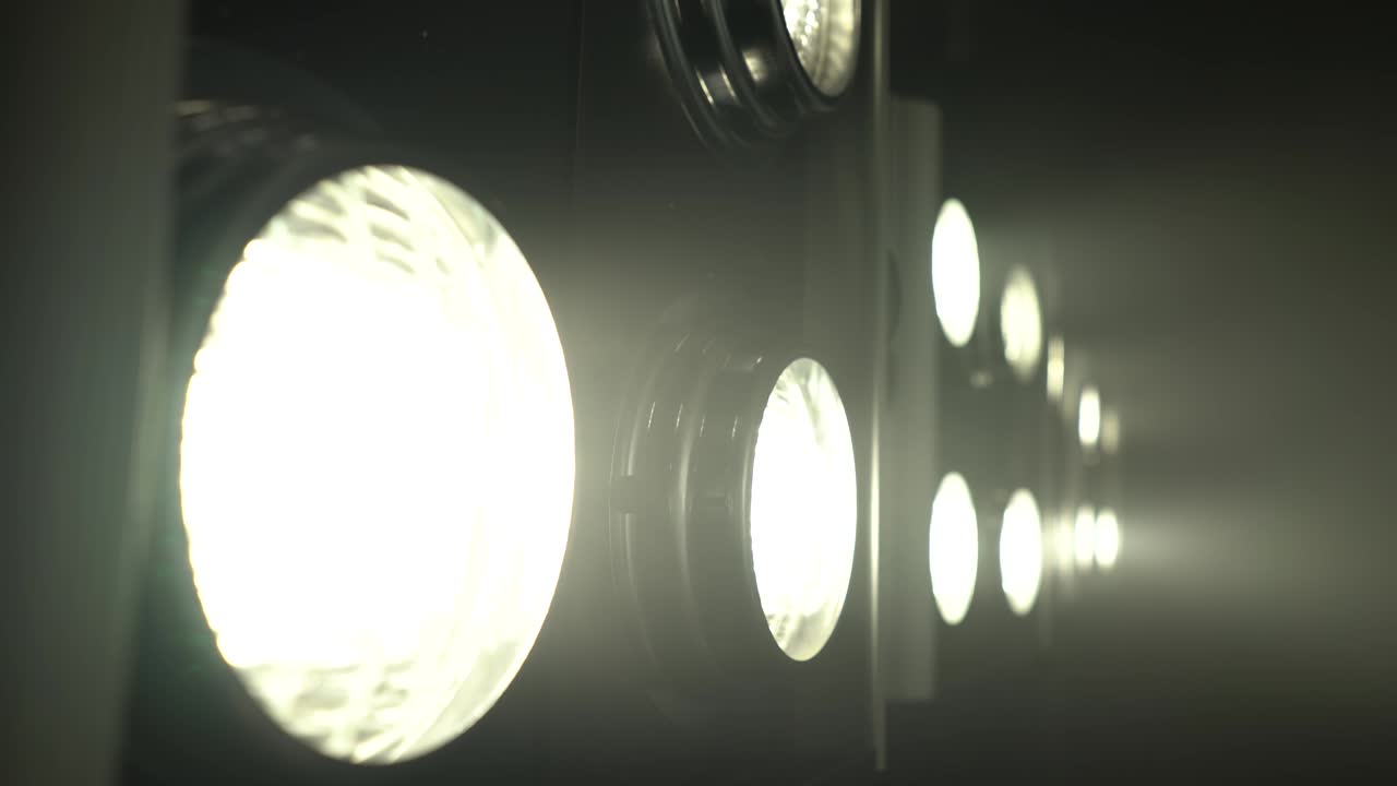 Large projectors with flickering light create color music . Close up